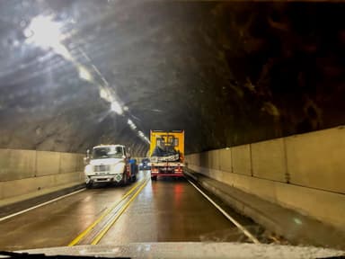 Un tunnel avec des camions et des lumières brillantes.