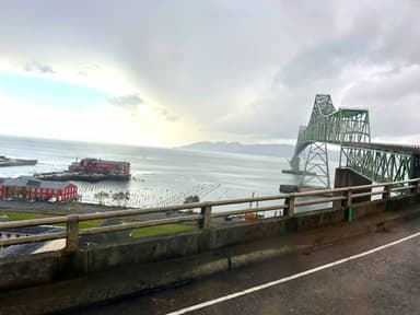 Un pont sur l'eau avec des nuages sombres en arrière-plan.