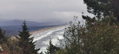 Une vue panoramique de la côte avec des vagues et des nuages.