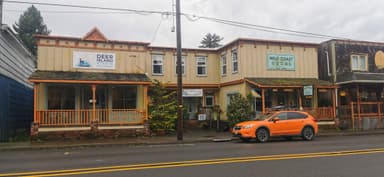Une rue avec des magasins colorés et une voiture orange.