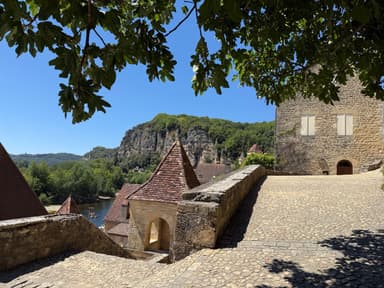 Une vue ensoleillée des maisons et de la rivière à Dordogne.