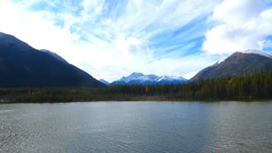 Un paysage de montagnes et d'un lac sous un ciel nuageux.