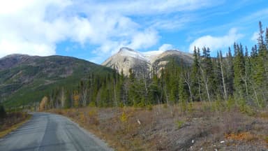 Une route menant à des montagnes sous un ciel bleu.