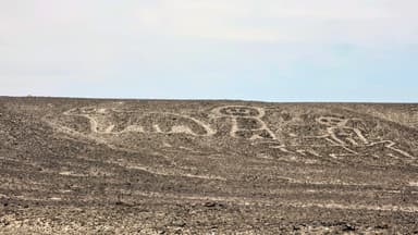 Des figures géantes gravées sur un terrain désertique.