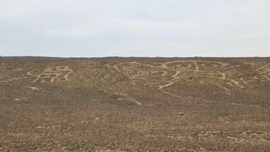 Des figures géométriques gravées sur le sol désertique.