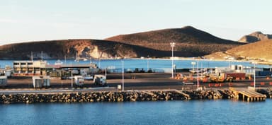 Un port avec des montagnes en arrière-plan et un ciel clair.