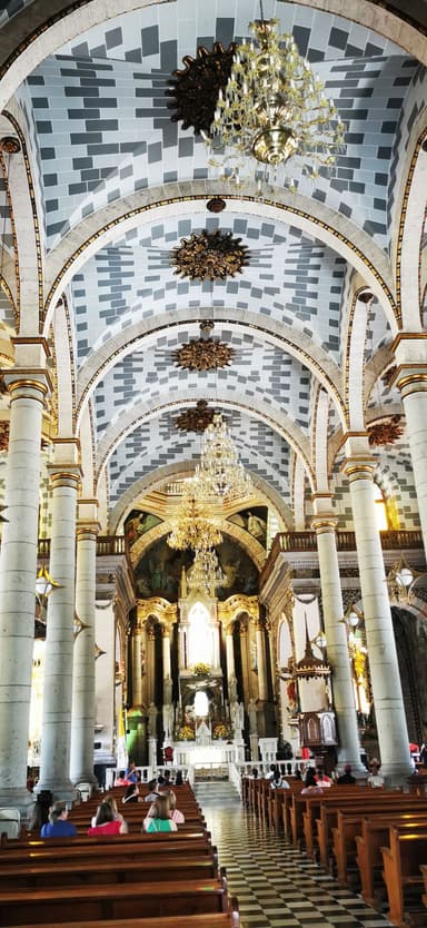 Intérieur d'une église avec des colonnes et un plafond décoré.