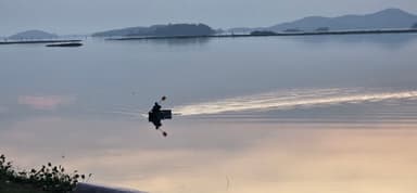 Un homme pagayant sur un lac calme au crépuscule.