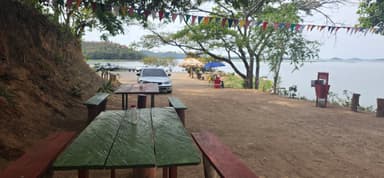 Une vue d'un espace extérieur avec des tables et un lac en arrière-plan.