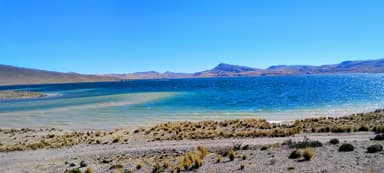 Un paysage de lac avec des collines sous un ciel bleu à Puquio.
