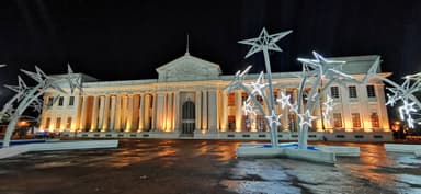 Un bâtiment éclairé la nuit avec des sculptures d'étoiles.