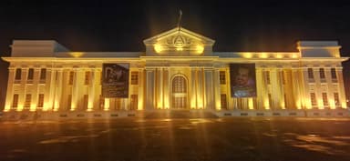 Un bâtiment illuminé la nuit avec des affiches.