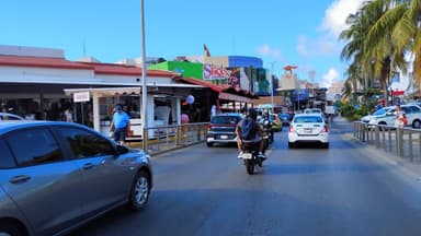 Une rue animée avec des magasins et des voitures à Quintana Roo.