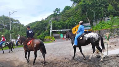 Des cavaliers à San Miguel, El Salvador, avec des arbres en arrière-plan.
