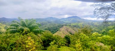 Une vue des collines verdoyantes de Veraguas, Panama, sous un ciel nuageux.