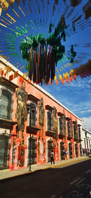 Une rue colorée avec des murs peints et des décorations suspendues.