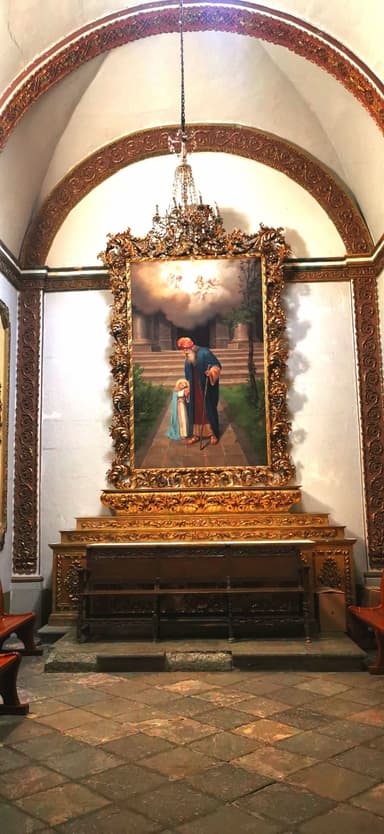Une peinture dans une église avec des détails dorés et un éclairage doux.