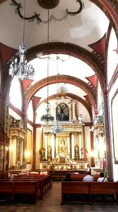 Intérieur d'une église avec des bancs et des décorations colorées.