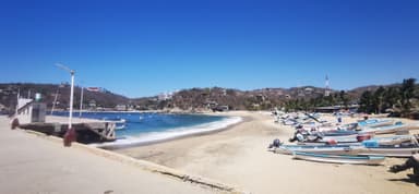 Une plage avec des bateaux et un ciel bleu à Oaxaca.