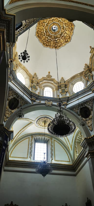 Une vue intérieure d'une église avec des détails architecturaux dorés.
