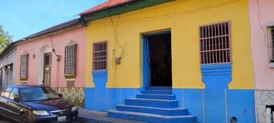 Une maison colorée avec des escaliers à San José, Guatemala, sous un ciel bleu.