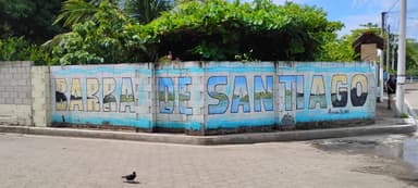 Un mur peint avec le nom d'un lieu, entouré de verdure.