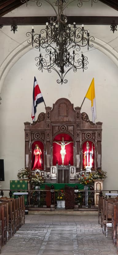 Une église avec un autel en bois et des drapeaux.