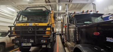Deux camions garés à l'intérieur d'un ferry.