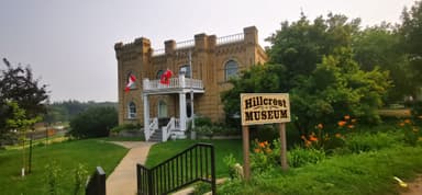 Un musée en briques avec des drapeaux et des fleurs autour.