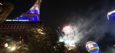 Une vue nocturne avec des feux d'artifice et une tour illuminée.
