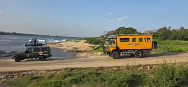 Deux véhicules sur une plage près d'une rivière au Venezuela.