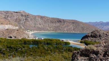 Une vue panoramique d'une baie entourée de collines et de végétation.