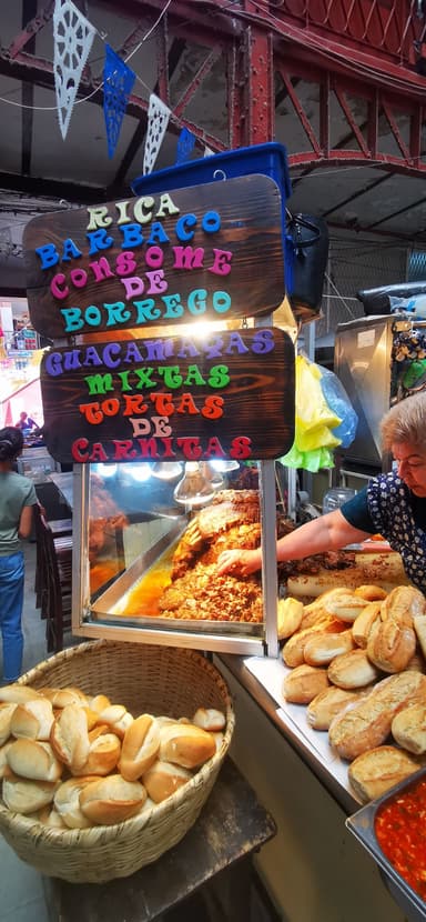 Un stand de nourriture avec des viandes et des pains dans un marché.
