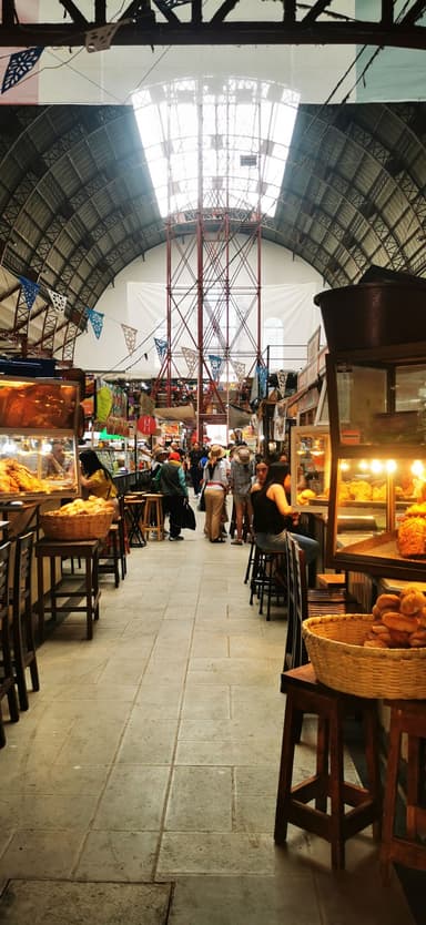 Un marché animé avec des stands de nourriture et des visiteurs.