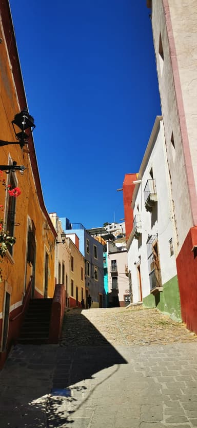Une rue colorée avec des bâtiments et un ciel bleu.