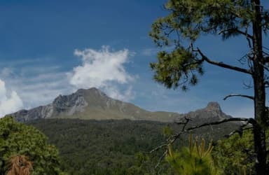 A mountain landscape with trees and blue sky in Tlaxcala.
