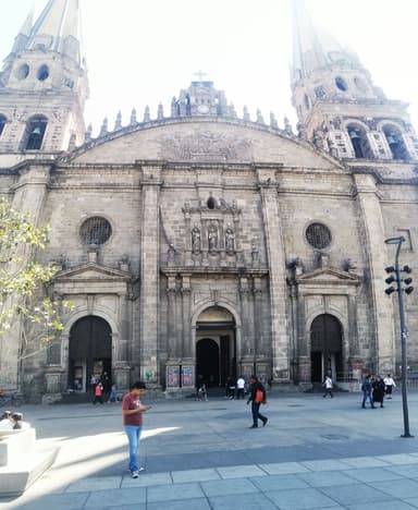 Une église historique avec des tours et des gens autour.