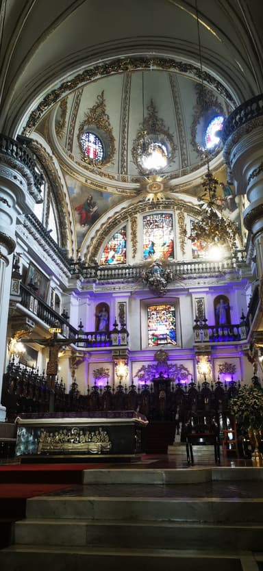 Intérieur d'une église avec des vitraux colorés et une architecture ornée.