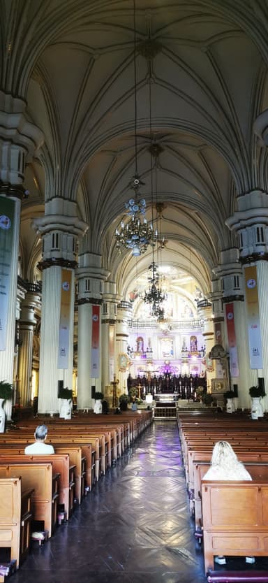 Une église avec de grandes arches et des bancs vides à Guadalajara.