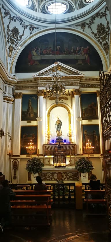 Une église avec des peintures et des bougies allumées.