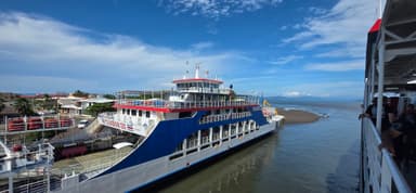 Un grand ferry dans un port sous un ciel bleu.
