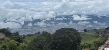 Une vue panoramique des nuages et des collines verdoyantes.