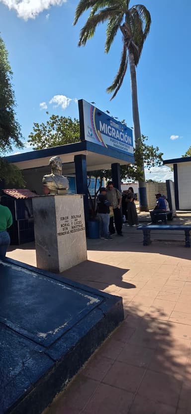 Un bâtiment avec une statue et des gens attendant à l'extérieur sous un ciel bleu.