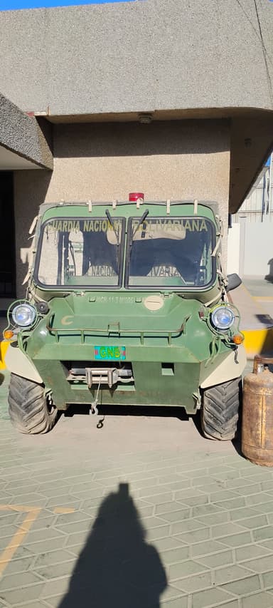 Un véhicule militaire vert stationné à l'extérieur.