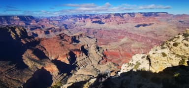 Un paysage du Grand Canyon avec des formations rocheuses et un ciel bleu.