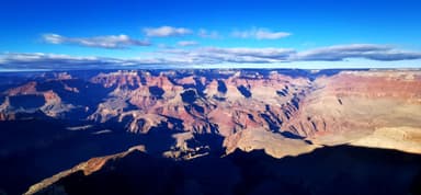 Un paysage du Grand Canyon avec des ombres et des nuages.