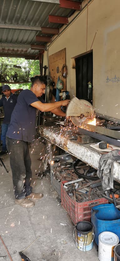 Un homme travaillant avec une meuleuse dans un atelier.