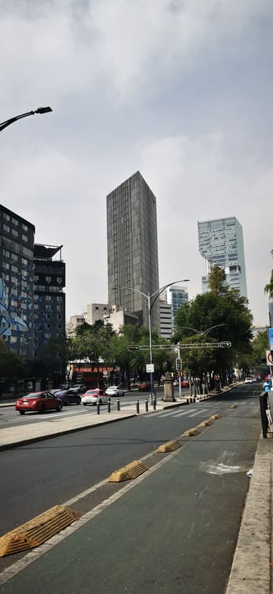 Une rue avec des bâtiments modernes sous un ciel nuageux.