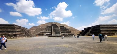 Une vue des pyramides sous un ciel bleu avec des nuages.