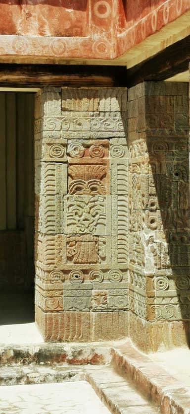 Une pierre sculptée avec des motifs anciens et des ombres sur le mur.